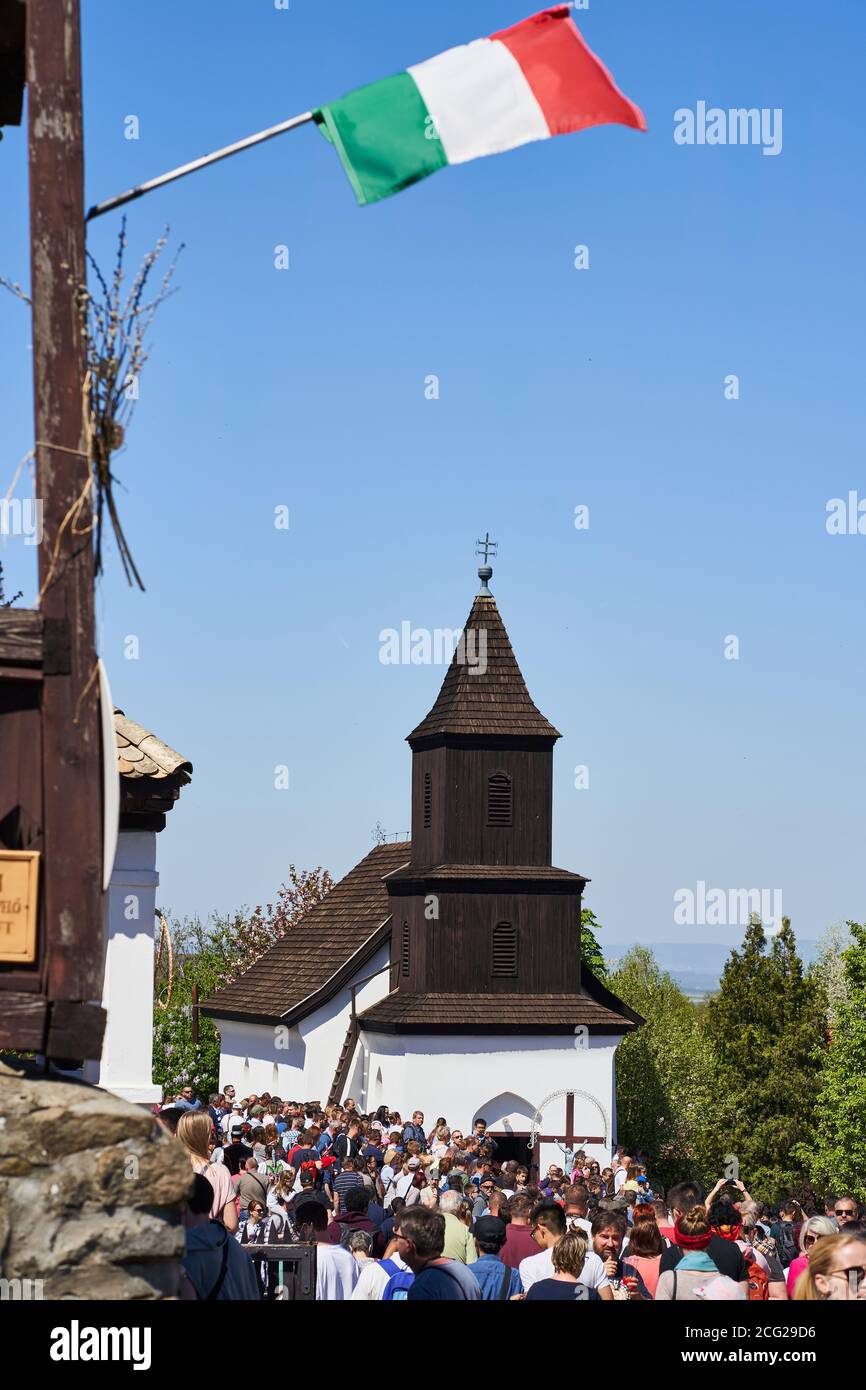 Bandera húngara sobre la antigua iglesia en un antiguo pueblo tradicional - Holloko, Hungría país Foto de stock