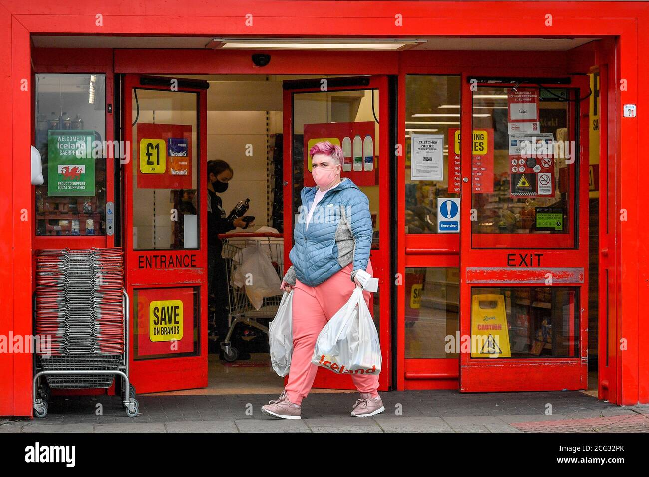 Los compradores usan máscaras dentro de las tiendas de alimentos en el centro de Caerphilly, ya que el condado de Caerphilly en el sur de Gales está bajo un bloqueo local tras un "aumento significativo" en los casos de coronavirus. No se permite a la gente entrar o salir de la zona sin una excusa razonable después de que las restricciones entraron en vigor a las 6pm del martes 8 de agosto. Foto de stock