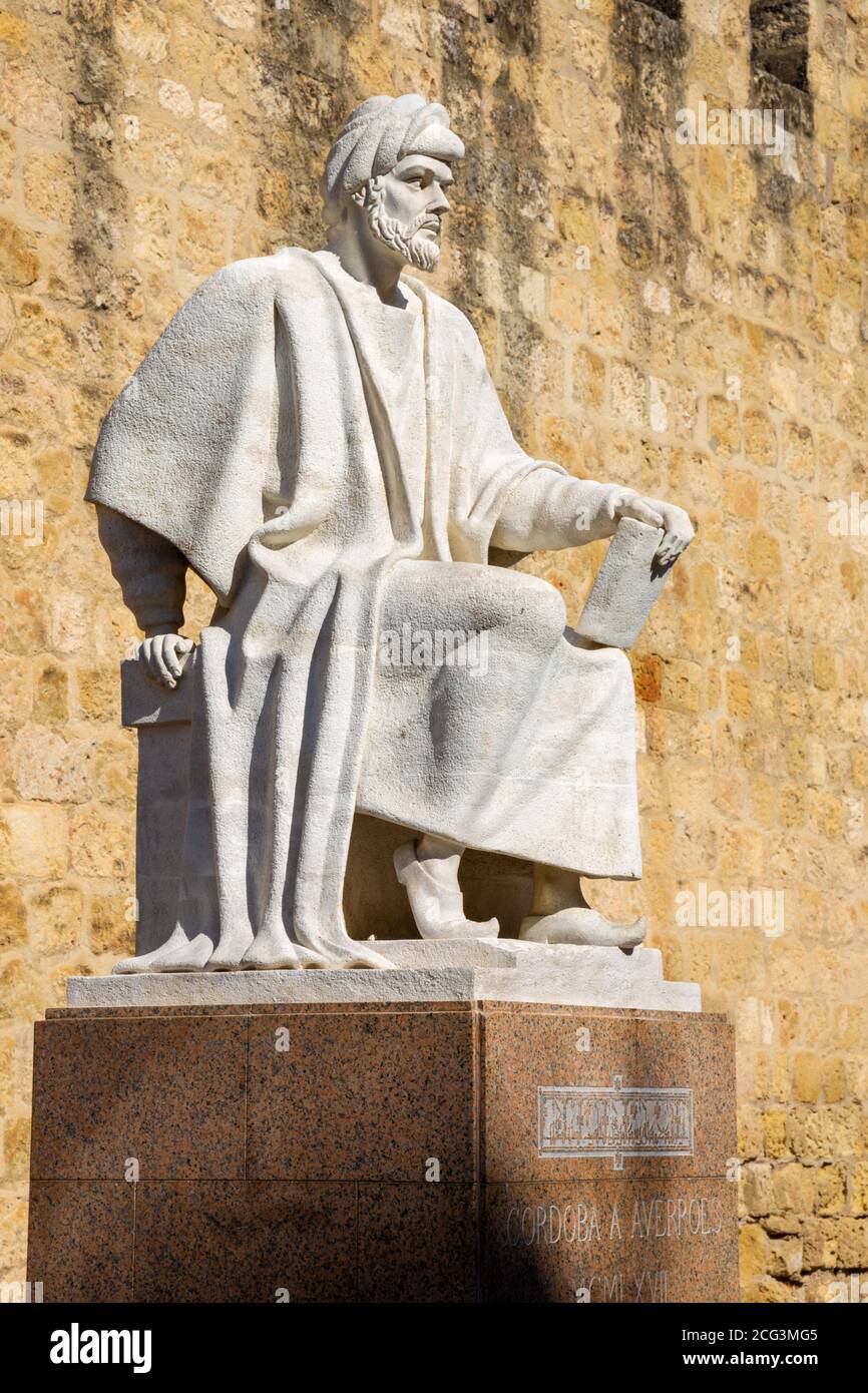 CORDOBA, España - 25 de mayo de 2015: La estatua del filósofo Averroes árabe medieval por Pablo Yusti Conejo (1967) y la muralla medieval. Foto de stock