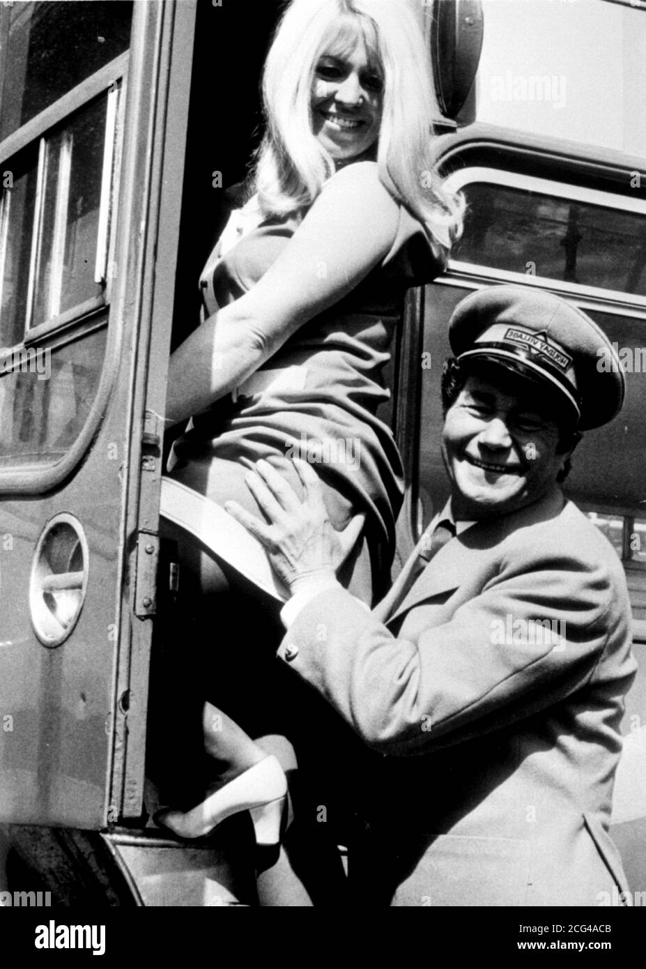 REG VARNEY, QUE DEJÓ LA TELEVISIÓN 'EN LOS AUTOBUSES' EN MARZO, ESTÁ DE VUELTA EN SU PAPEL COMO CONDUCTOR DE AUTOBÚS STAN BUTLER EN 'VACACIONES EN LOS AUTOBUSES', TERCERA PELÍCULA BASADA EN LA SERIE TELEIVSION. AQUÍ ESTÁ CON CARLOAE DONOGHUE DURANTE EL RODAJE EN EL NORTE DE GALES Foto de stock