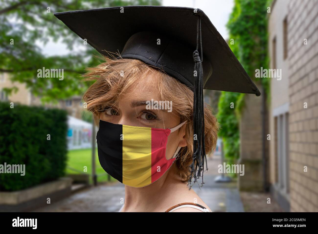 Estudiante Graduación con diseño belga protector coronavirus máscara en La ceremonia de Graduación en la Universidad Foto de stock
