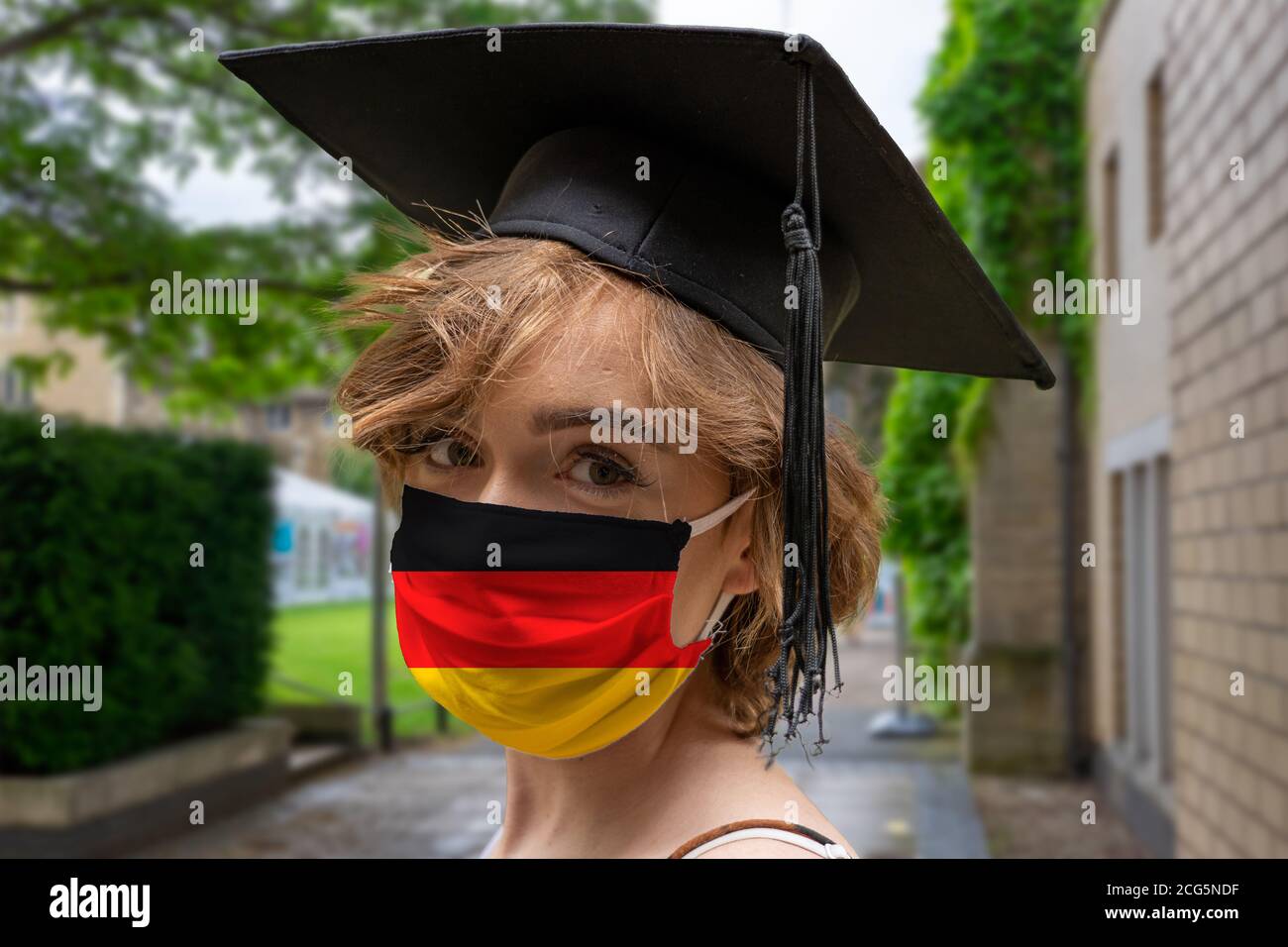 Estudiante Graduación con diseño alemán protector coronavirus máscara facial en La ceremonia de Graduación en la Universidad Foto de stock