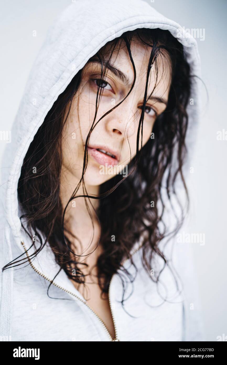 Retrato de una hermosa mujer con el cabello mojado usando un sudadera con capucha Foto de stock