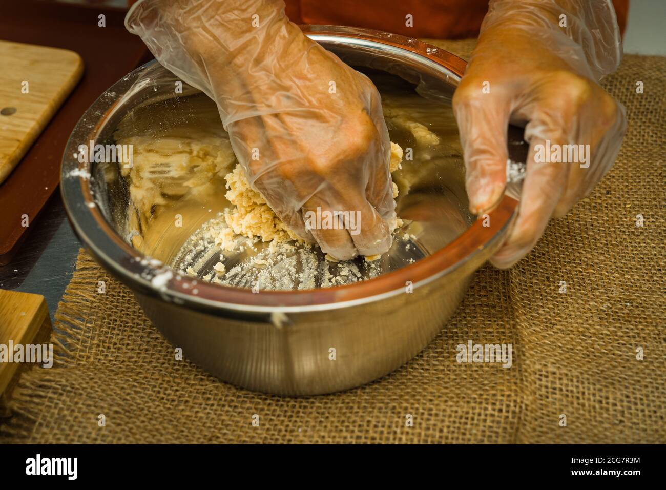 Las manos femeninas hacen masa para la torta de luna, pastelería cantonesa casera de la torta de luna en la bandeja de hornear antes de hornear para el festival tradicional. Viajes, vacaciones, fo Foto de stock