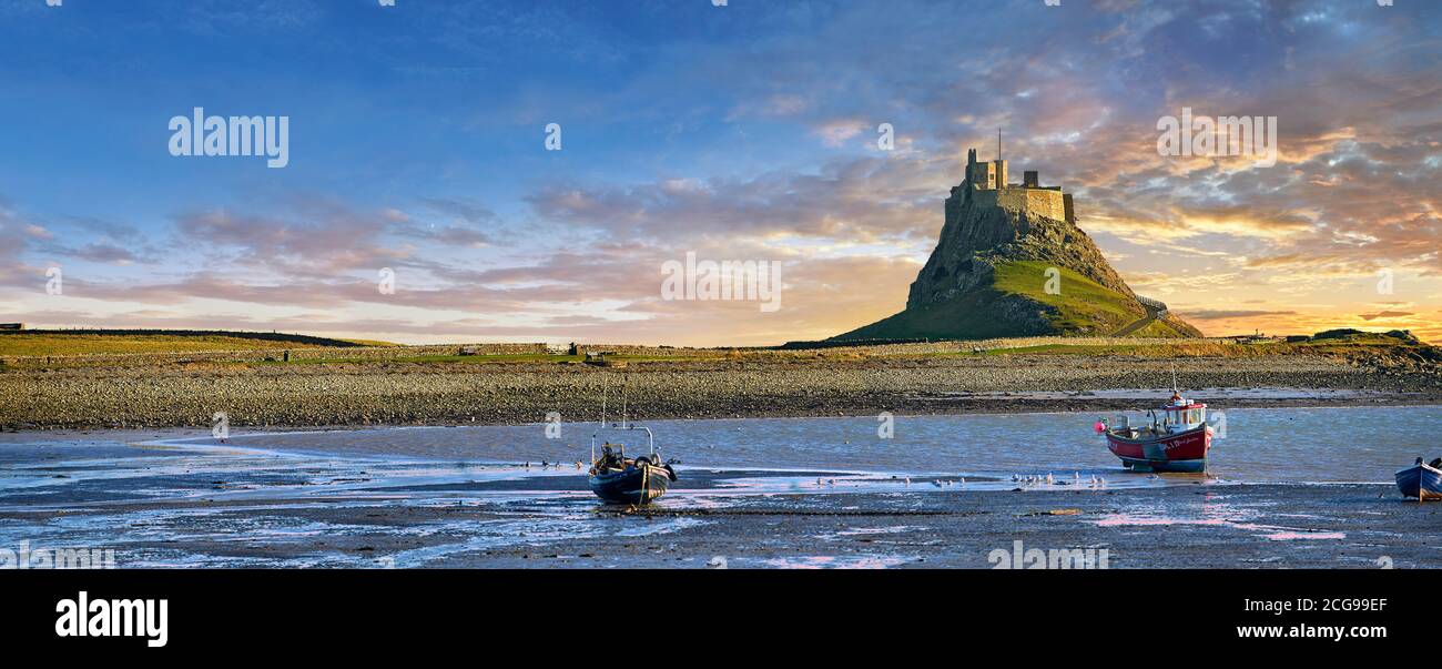 Castillo de Lindisfarne y barco de pesca al atardecer- Castillo del siglo XVI, Isla Santa, Lindisfarne, Northumberland, Inglaterra Foto de stock