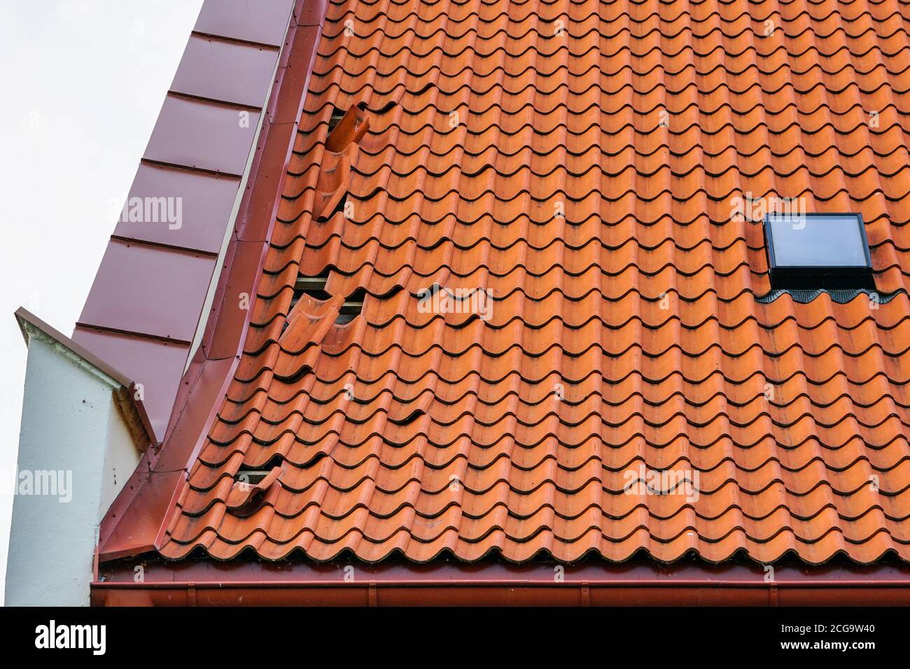 daños en el techo de baldosas de arcilla, algunas baldosas caídas Foto de stock