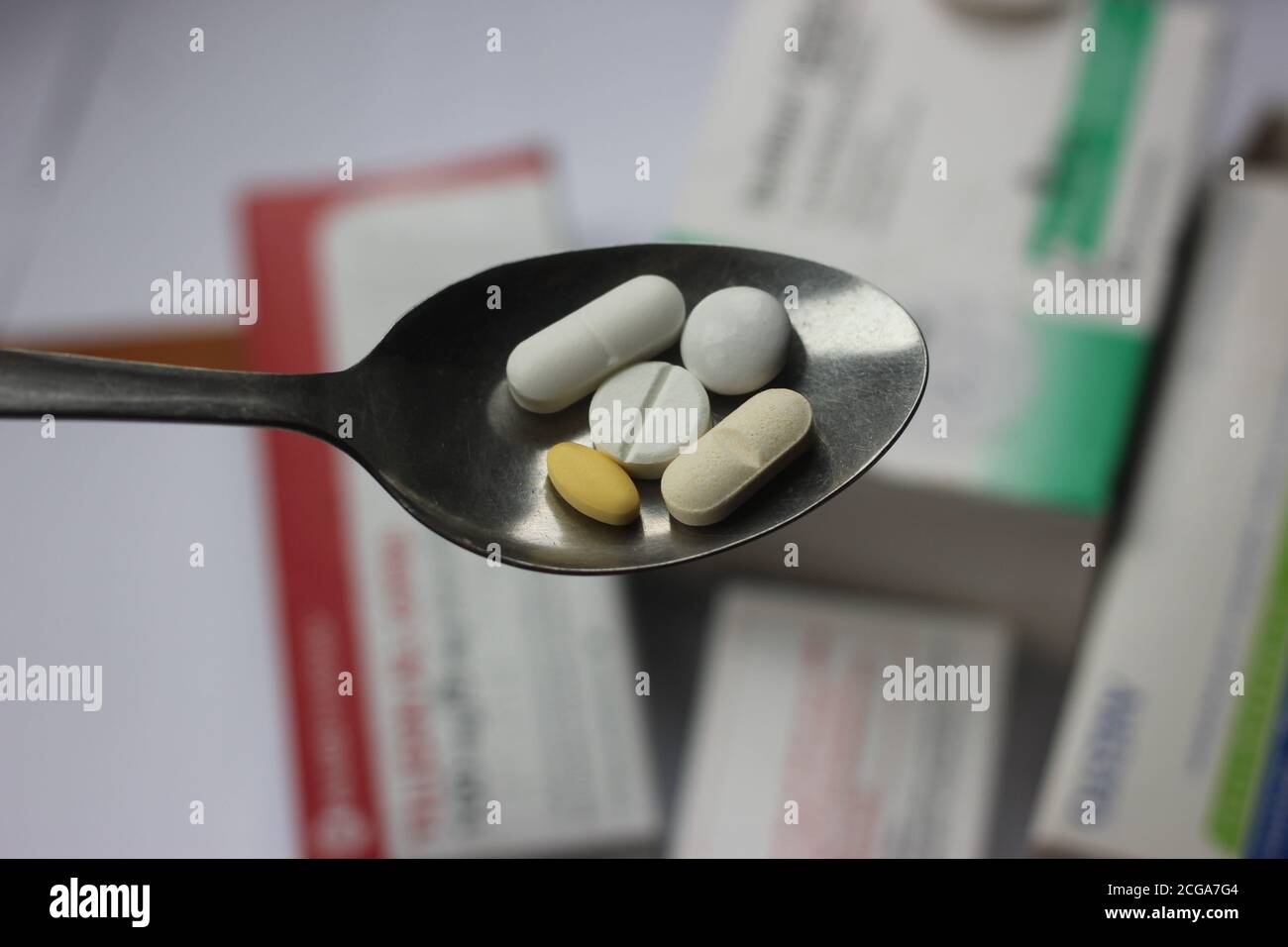 Tabletas en la cuchara. Administración de medicamentos. Tema interacción drogas-drogas. Foto de stock