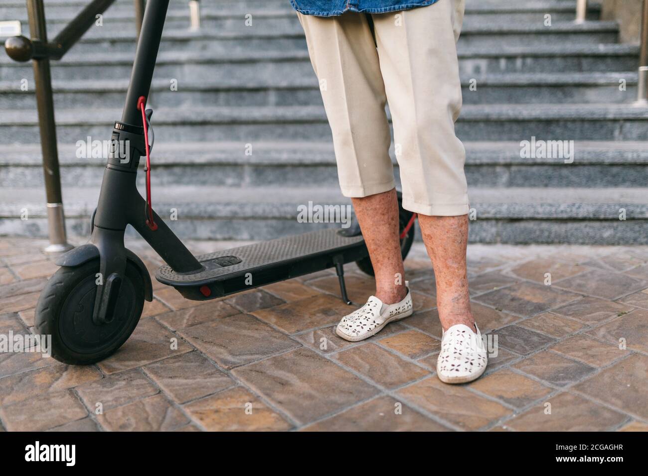 mujer de 90 años de edad con pelo gris, arrugas, progresivo y activo  utiliza moderno scooter de transporte eléctrico. Señora pensionista utiliza  la ciudad ecológica Fotografía de stock - Alamy