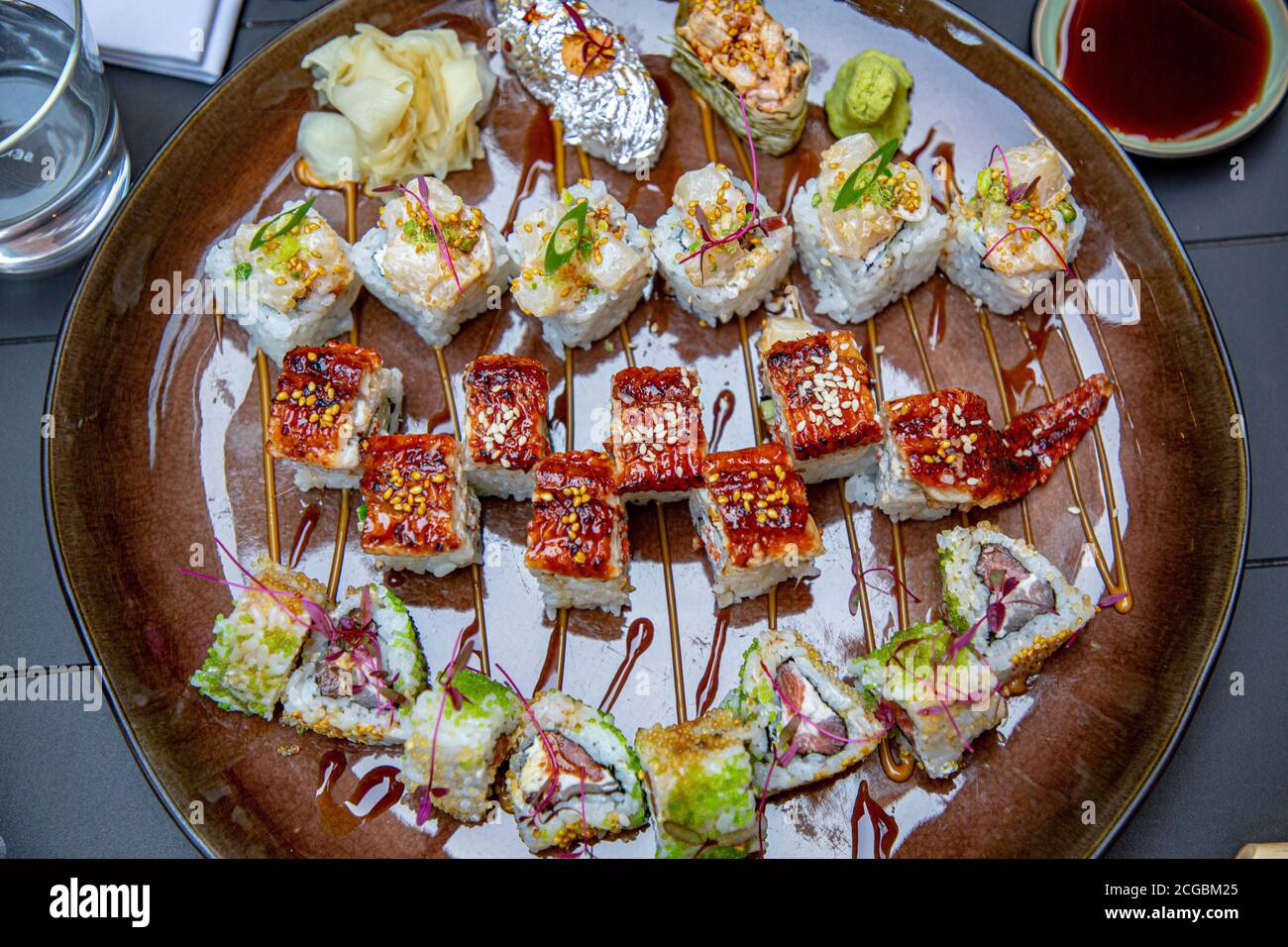 Diferentes rollos japoneses y sushi en un plato. Rollo con anguila. Foto de stock