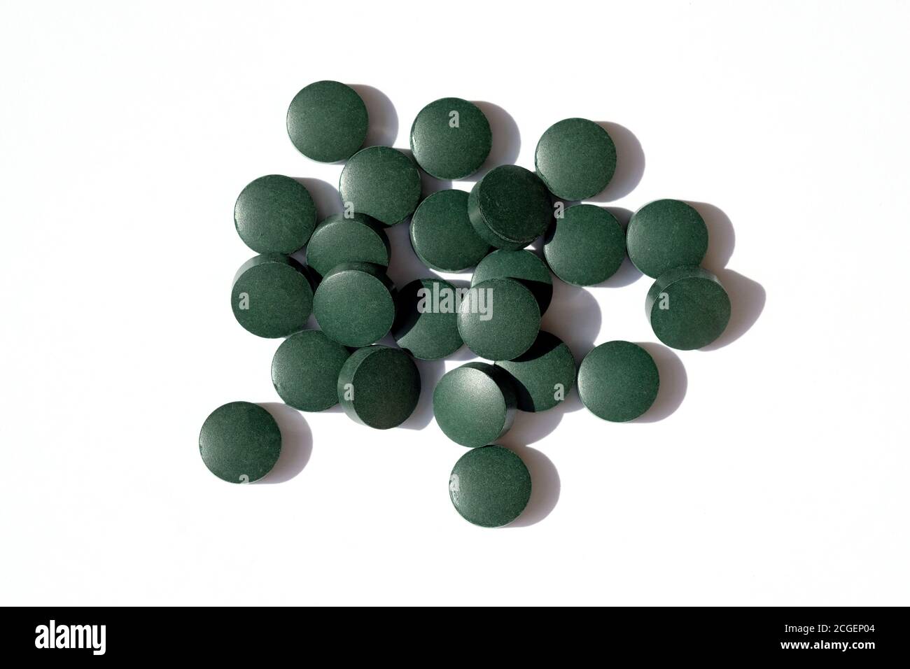 Pastillas verdes redondas sobre un fondo blanco vista superior. Las tabletas de Chlorella son suplementos alimenticios. Spirulina en forma de píldora. Foto de stock