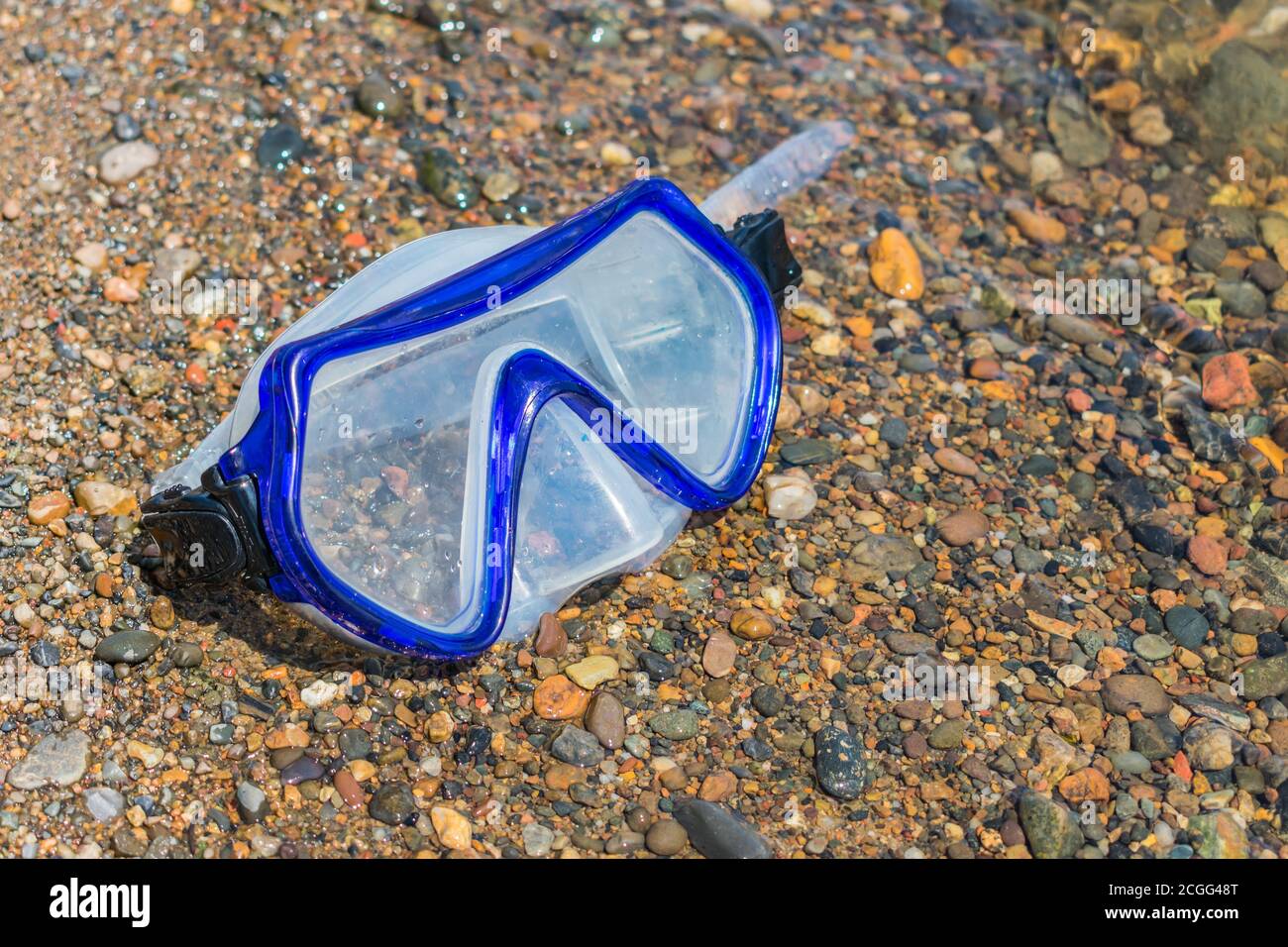 Las gafas de buceo perdidas se encuentran en un guijarro de río en la  orilla. Accesorios de buceo Fotografía de stock - Alamy