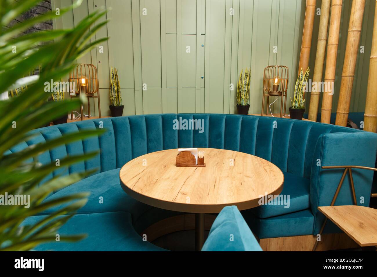 Gran sofá redondo en azul para una gran empresa alrededor de una mesa  redonda de madera. Interior de un restaurante Fotografía de stock - Alamy