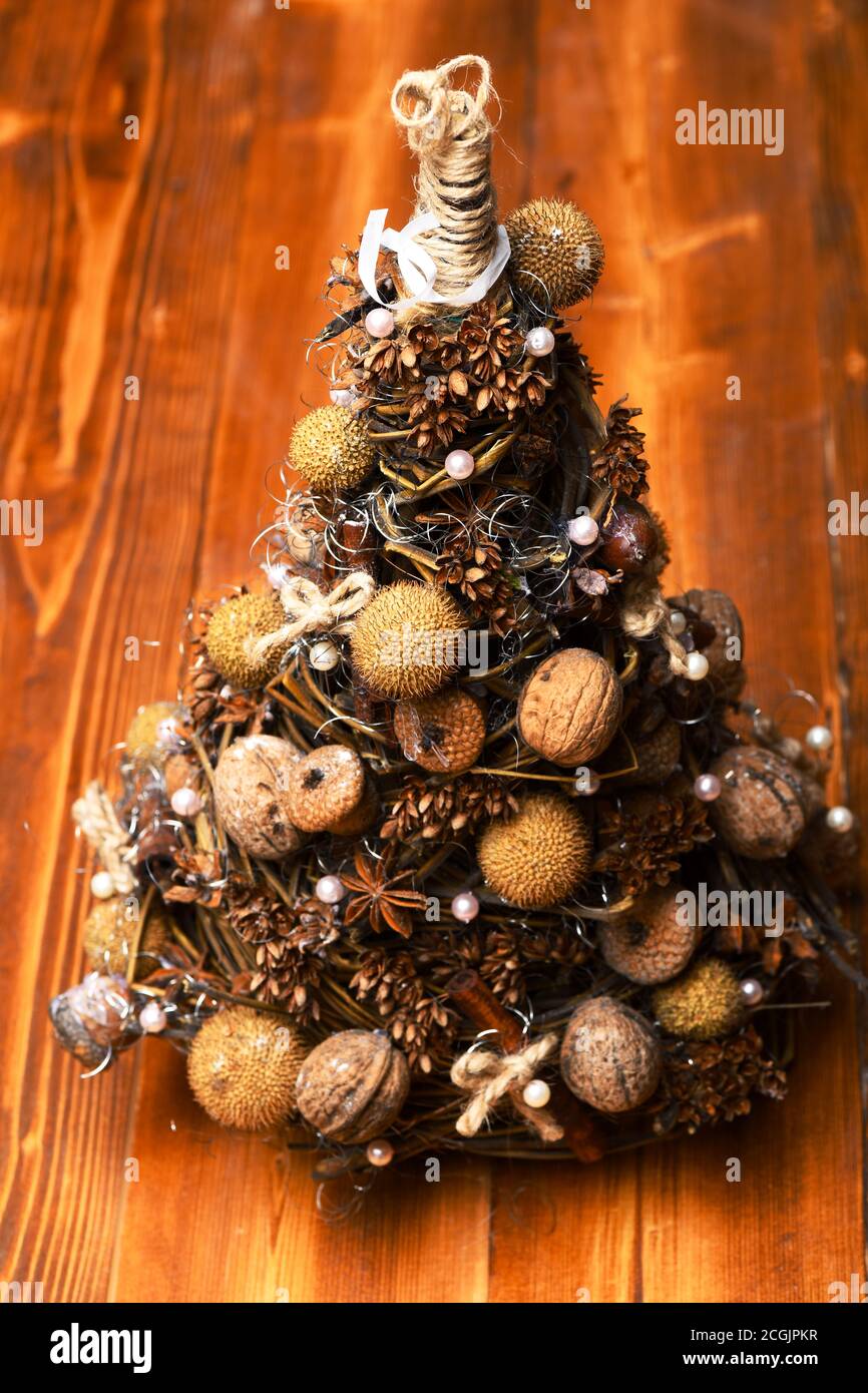 Abeto decorado con nueces, anís seco y bellotas. Modelo de árbol de Navidad  hecho de ramas de uva. Navidad decoración concepto. Conos y frutos secos  sobre un pequeño árbol sobre fondo de