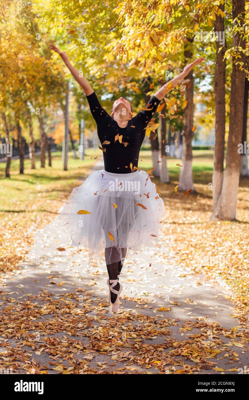 Mujer bailarina en una falda de ballet blanco bailando en zapatos pointe en  un parque de oro otoño sobre hojas amarillas secas Fotografía de stock -  Alamy