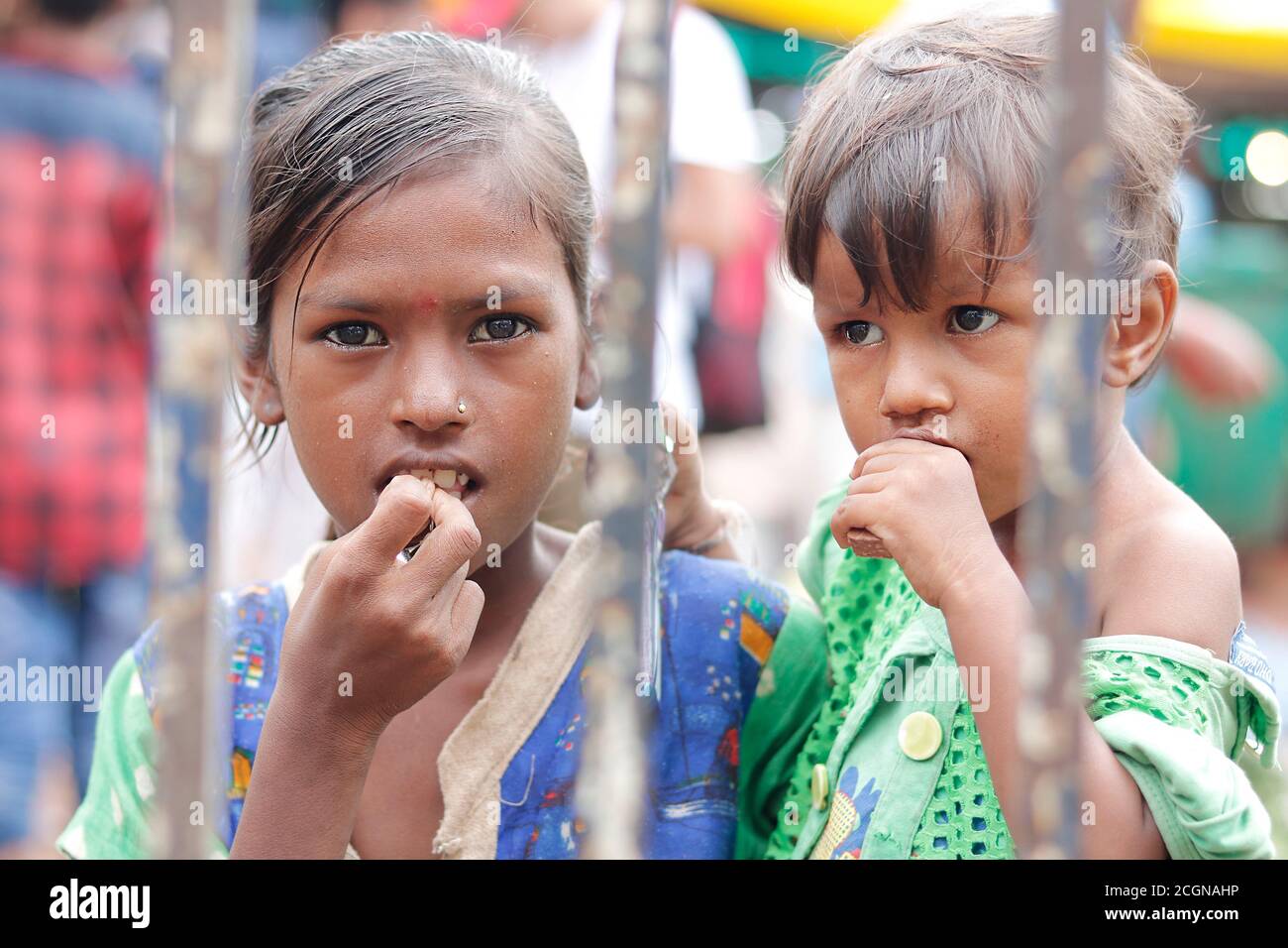 Ahemdabad, Gujarat, India - 20 de junio de 2019: Pobre india desamparada niña de la calle sosteniendo a un pequeño niño en la mano mira la cámara, buscando ayuda, la pobreza concepta Foto de stock