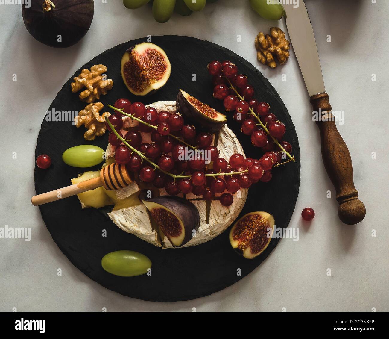 Queso Camembert al horno con miel, frutas, frutos secos y bayas Fotografía  de stock - Alamy