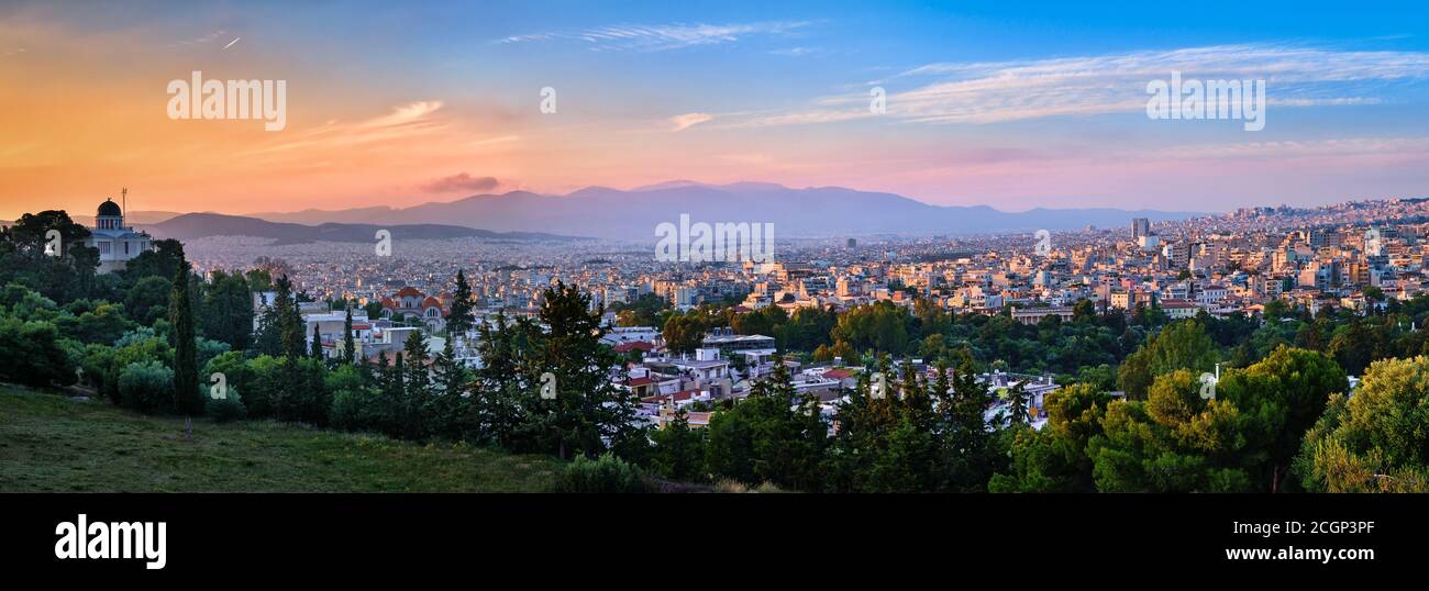 Vista de Atenas, Grecia y las zonas residenciales de la colina de Pnyx en la suave luz del sol de la noche, gran cielo de la puesta de sol. Observatorio Nacional de Atenas en primer plano. Foto de stock