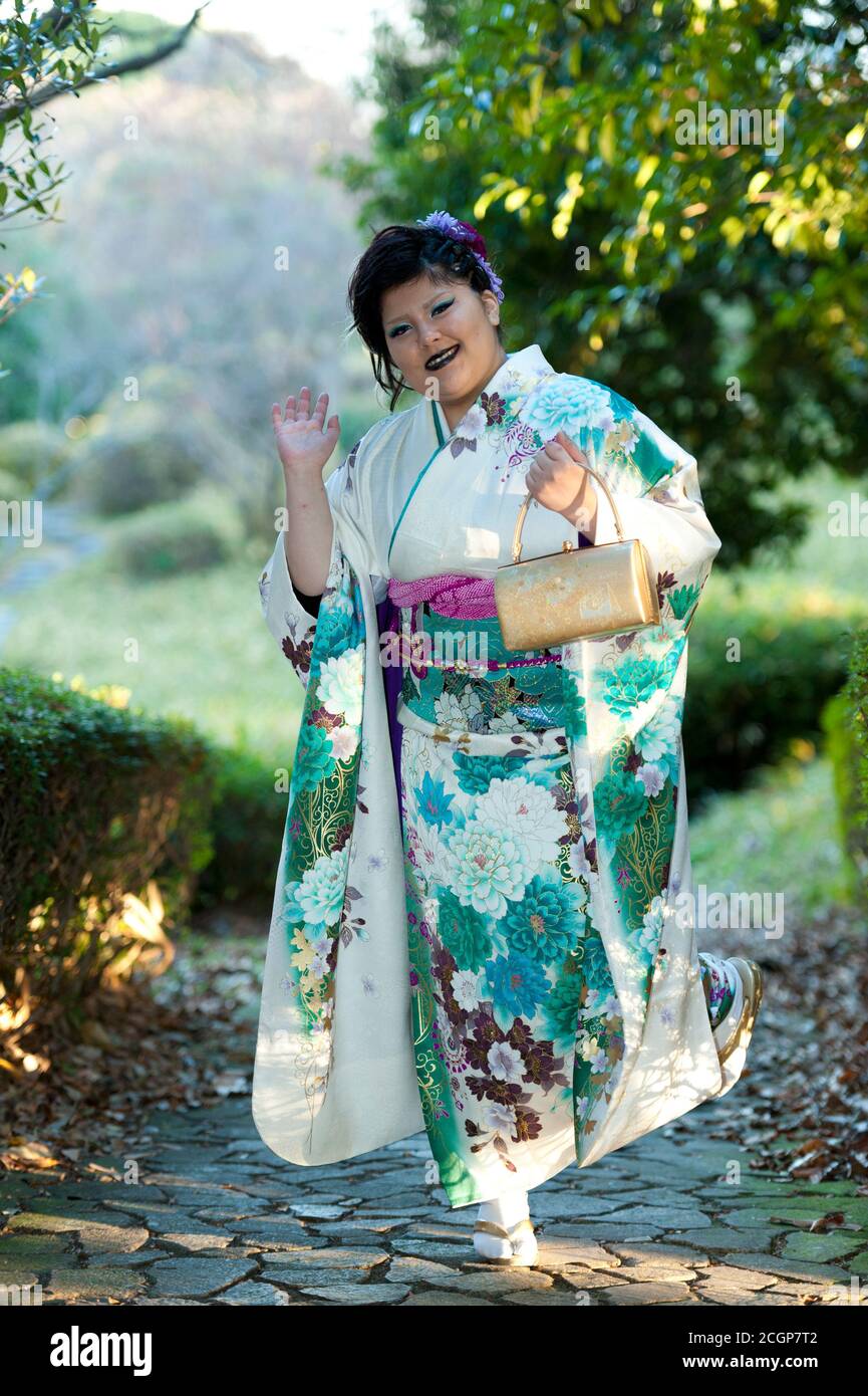 Hermoso adolescente japonés con kimono sonriendo y esperando con interés celebrar la llegada del día de la Edad en la ciudad de Fuji, Japón. Disparo vertical. Foto de stock