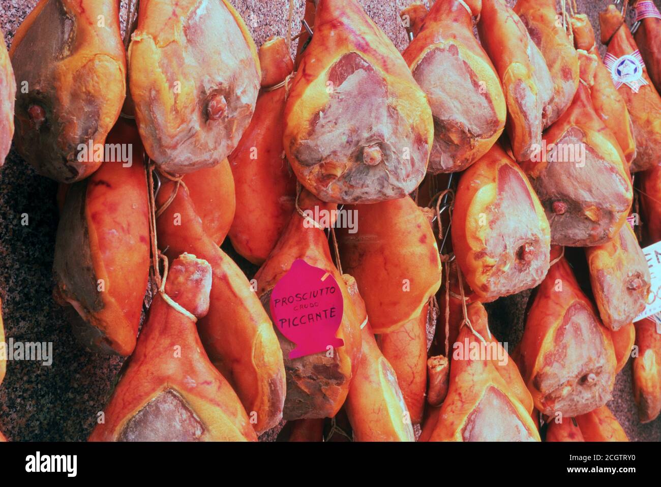 Jamón italiano o prosciutto colgando en la carnicería en Rimini Foto de stock