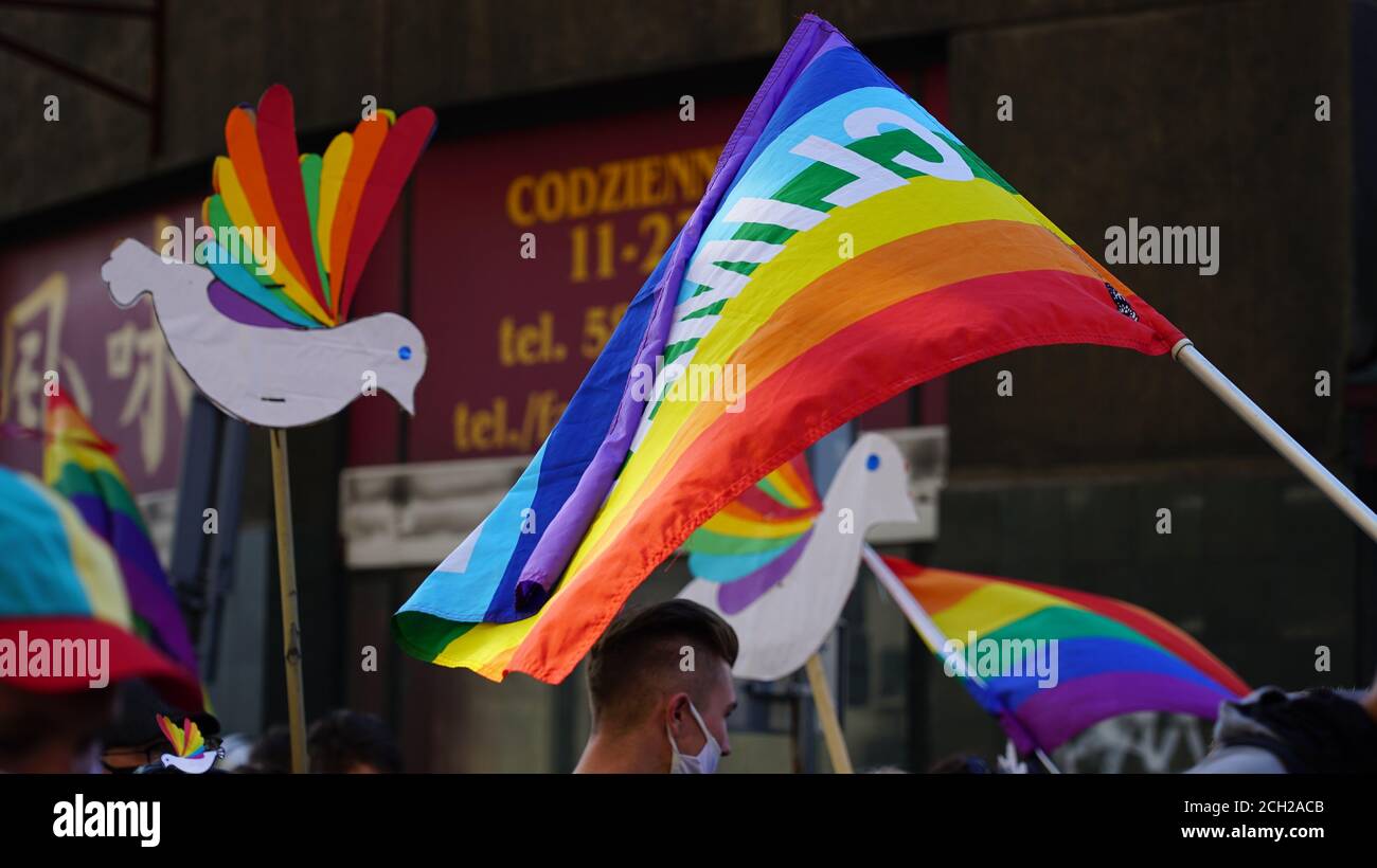 Igualdad LGBT marcha. Los jóvenes que usan ropa y símbolos de arco iris luchan por los derechos de LGBTQ+. Banderas del arco iris, banderas. Foto de stock