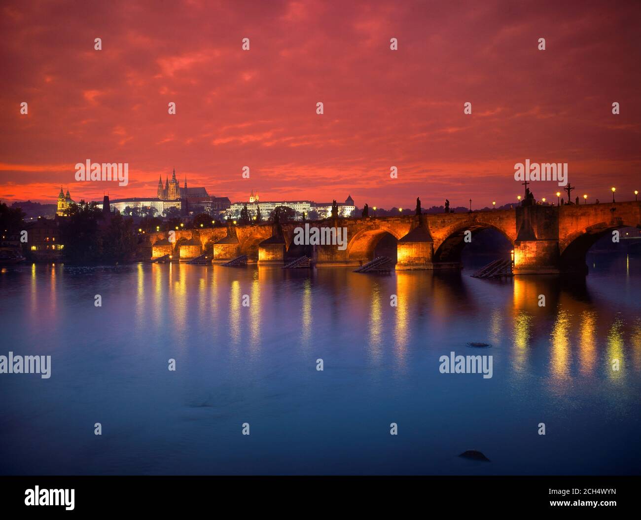 Puente de Carlos a través del río Vltava, iluminado en la noche con Hradcany Castillo y la Catedral de San Vito Foto de stock