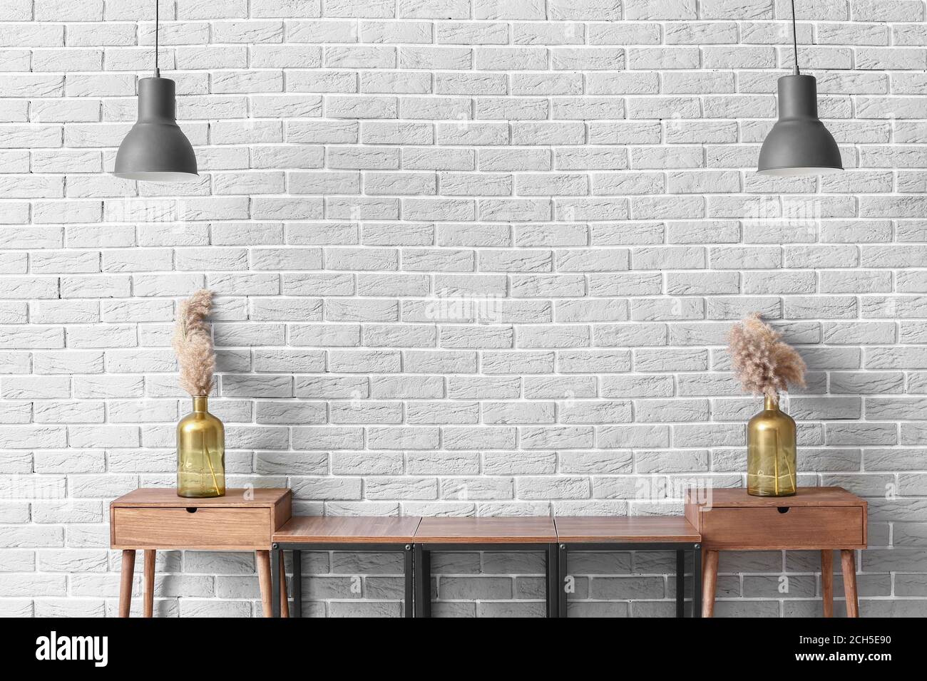 Puesto de madera con decoración y lámparas cerca de la pared de ladrillo  gris en la habitación Fotografía de stock - Alamy