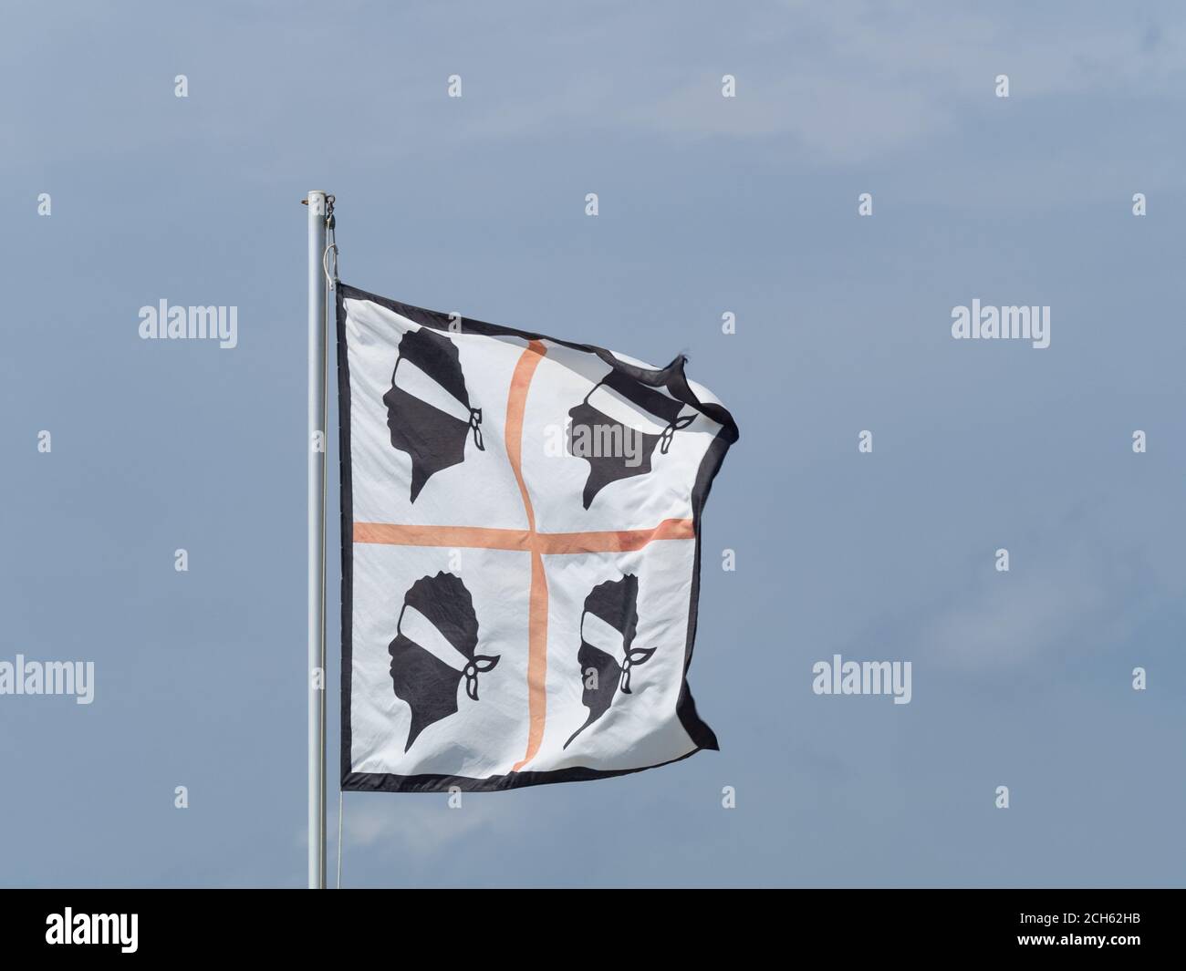 La bandera de Cerdeña flúter en el viento . llamada la bandera de los cuatro moros representa la isla de Cerdeña (Italia) Foto de stock