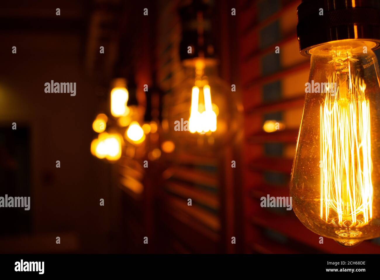 Lámparas antiguas doradas de estilo Edison en la oscuridad. Concepto de decoración de iluminación. Bombillas de época. Fondo difuminado de luces retro Foto de stock