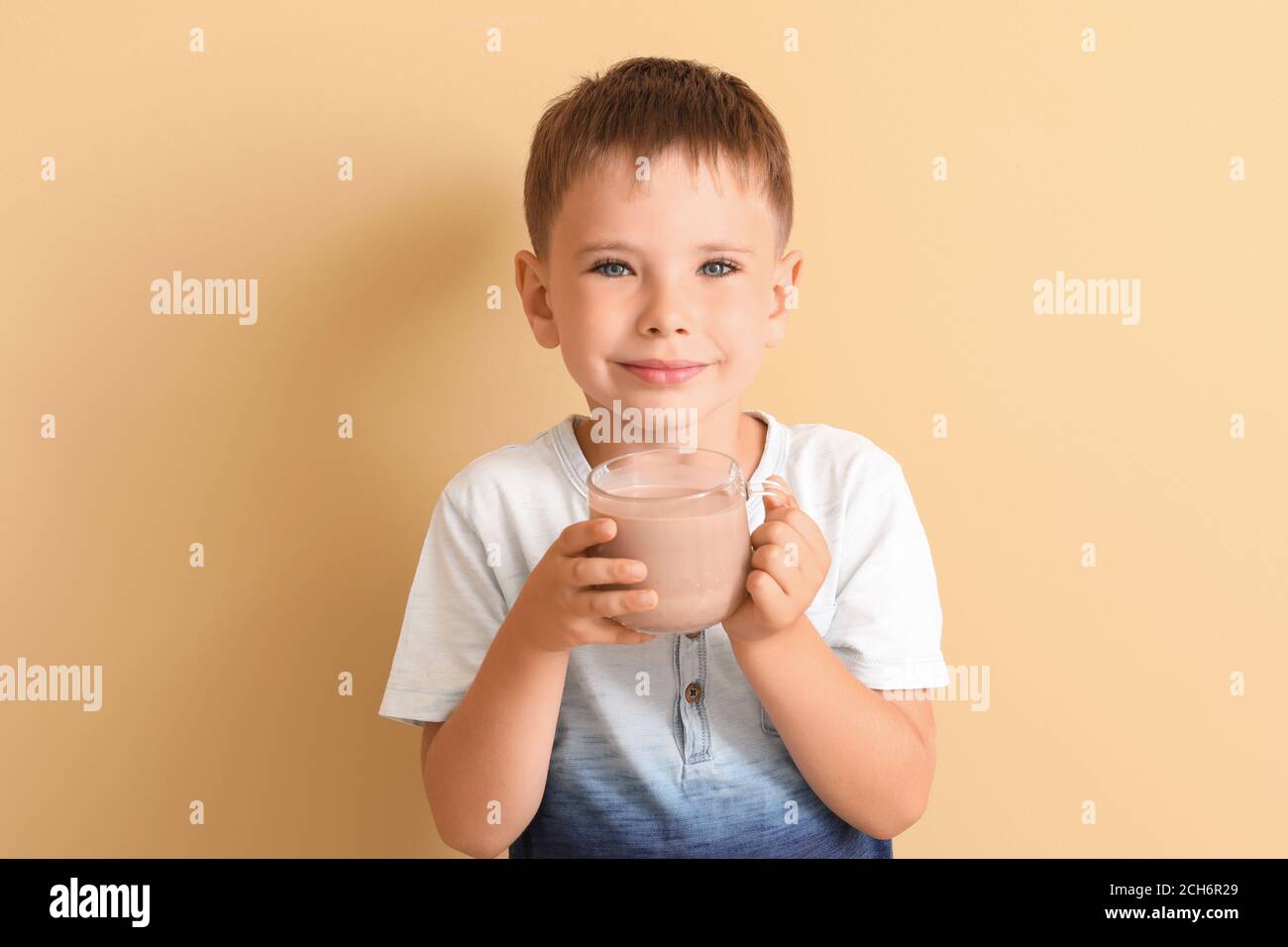 Niño que bebe leche de chocolate y que come galletas en casa Fotografía de  stock - Alamy
