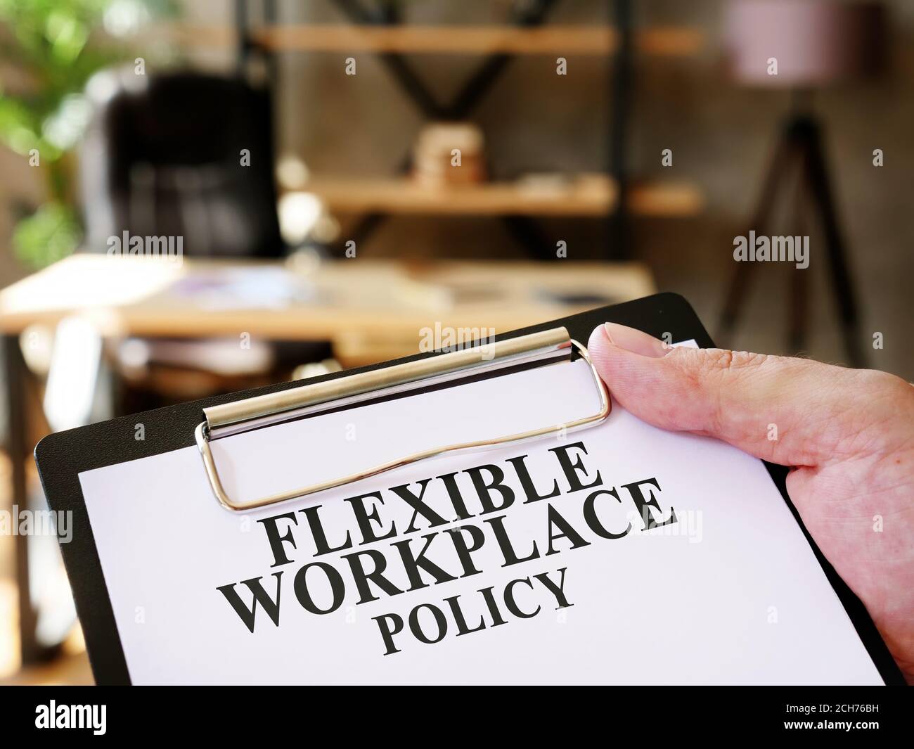 El gerente está leyendo la política de flexibilidad en el lugar de trabajo en la oficina. Foto de stock
