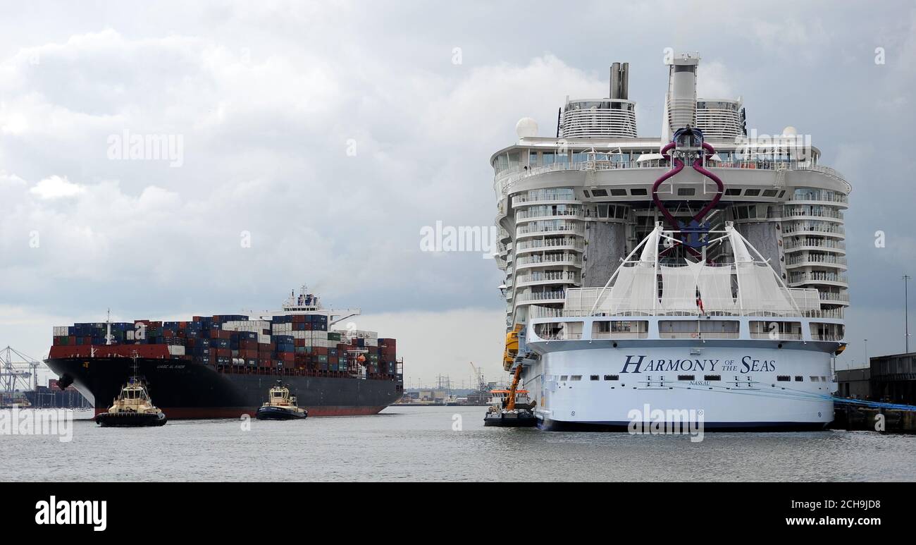 Vs Titanic Crucero Mas Grande Del Mundo Un barco de contenedores pasa por el buque de pasajeros más grande del mundo,  MS Harmony of the Seas, propiedad de Royal Caribbean, mientras espera salir  de Southampton Fotografía de stock -