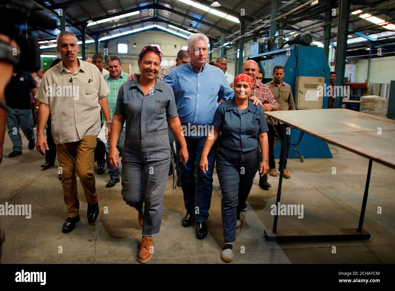 El presidente de Cuba, Miguel Díaz-Canel, camina con sus empleados durante  una visita a una fábrica de calentadores solares de agua en Ciego de Ávila,  Cuba, el 28 de noviembre de 2019.