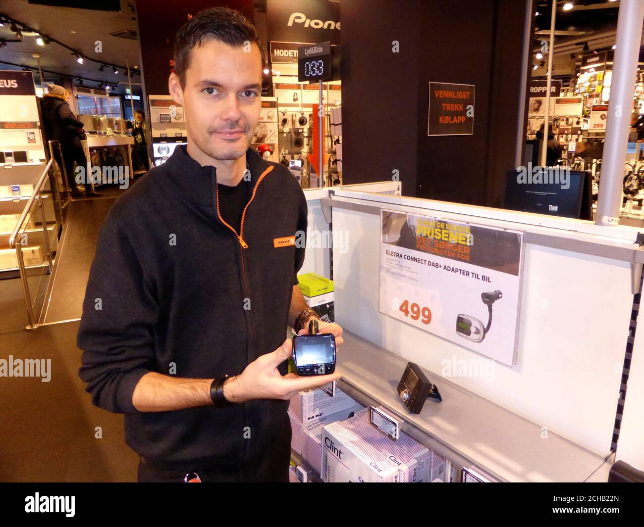 Worker Ino Andre Nilsen shows an adapter that can be plugged into a car FM  radio in an Expert City electronics shop in Oslo, Norway January 4, 2017.  Picture taken January 4,