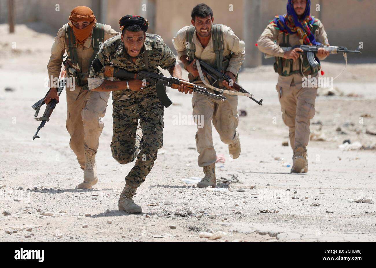 bolita espejo de puerta Renacimiento Combatientes kurdos de las unidades de Protección del Pueblo (YPG) corren a  través de una calle en Raqqa, Siria, el 3 de julio de 2017. Goran  Tomasevic: Eran miembros de la milicia