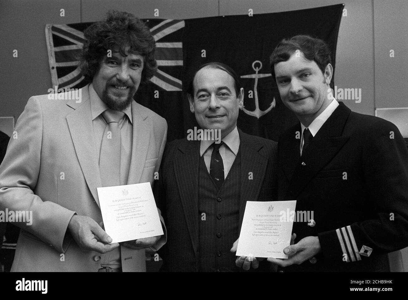 Marino Grado uno Roger Williams (l), de Bristol, y el Oficial de Tercer Ingeniero Roger Stevens (r), de Portland, con sus recomendaciones de la Reina para la valentía. Entre ellos está su capitán de la Engadina Auxiliar de la flota Real, el capitán David Freeman, que recibió la medalla de campaña. Foto de stock