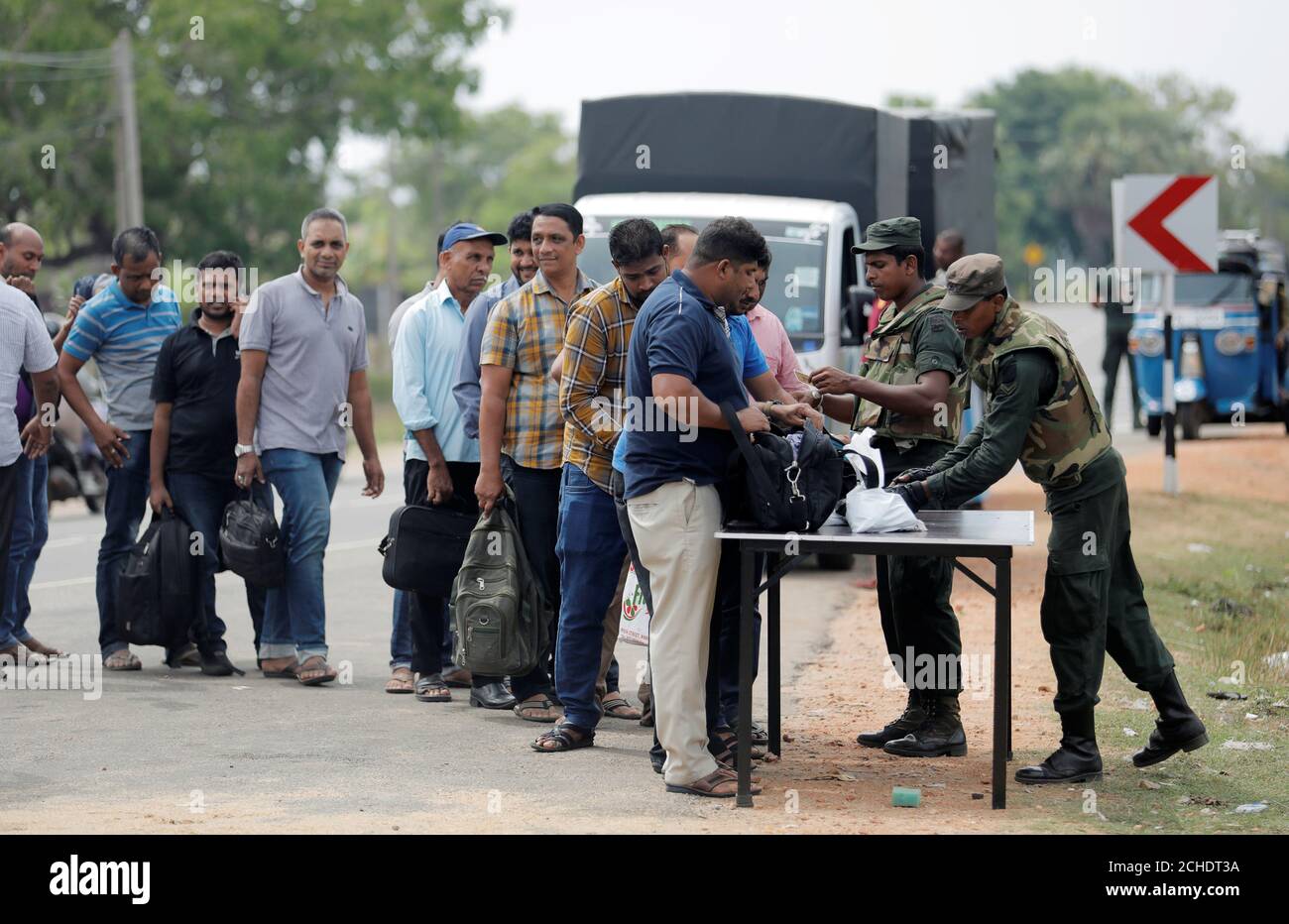 El personal del ejército de Sri Lanka busca a personas y sus bolsos en un punto de control en la aldea de Kattankudy en Batticaloa, Sri Lanka, 28 de abril de 2019. REUTERS/Dinuka Liyanawatte Foto de stock