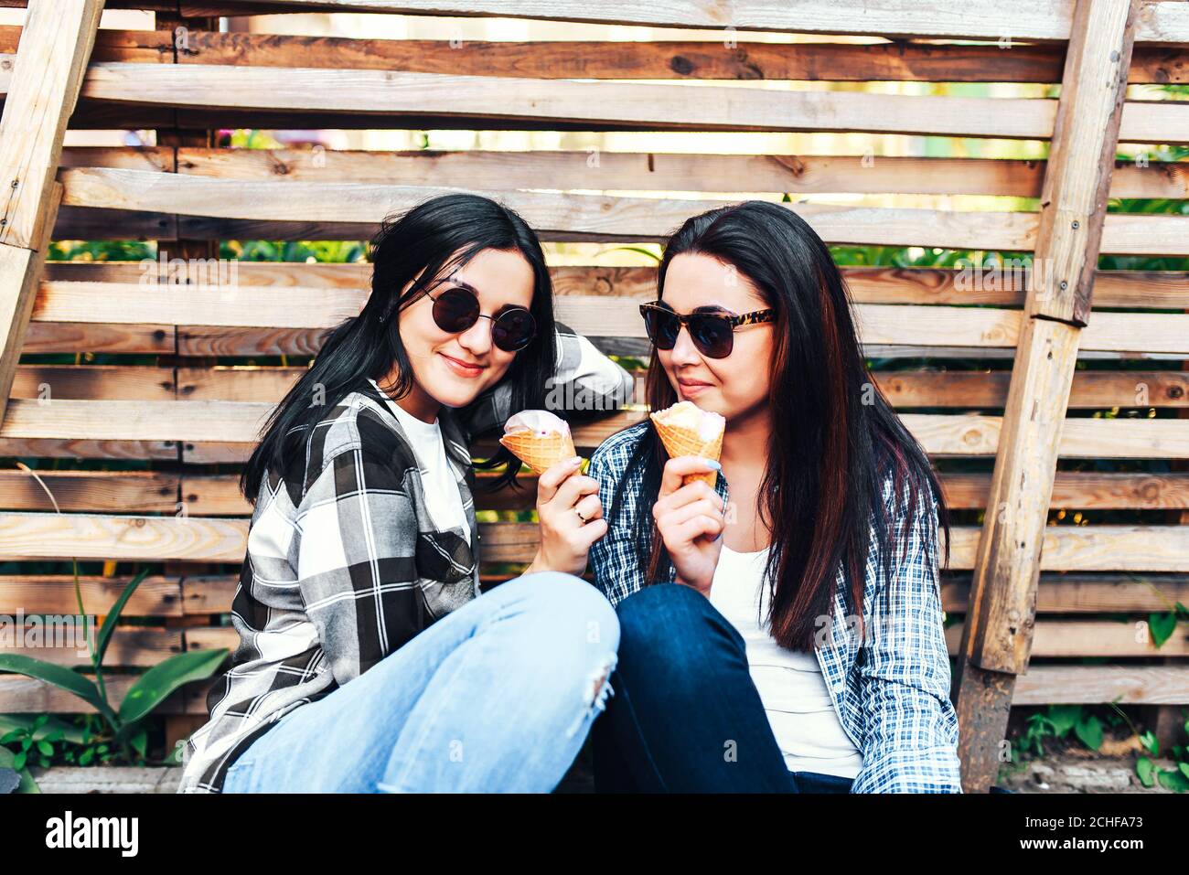 Dos chicas bonitas hablando y comiendo helado al aire libre Fotografía de  stock - Alamy