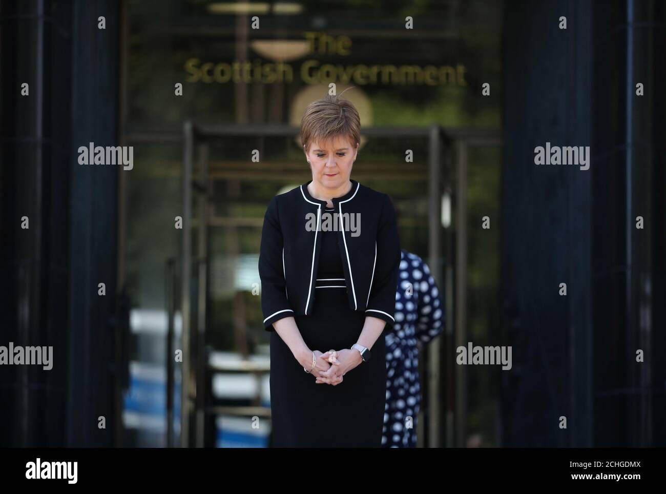 El primer Ministro Nicola Sturgeon se encuentra en las afueras de la Casa de San Andrés en Edimburgo para guardar un minuto de silencio en homenaje al personal del NHS y a los trabajadores clave que han muerto durante el brote de coronavirus. Foto de stock