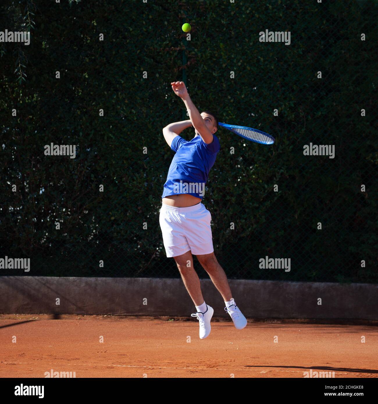 Jugador de tenis profesional que realiza primer servicio potente con un rebote salto Foto de stock