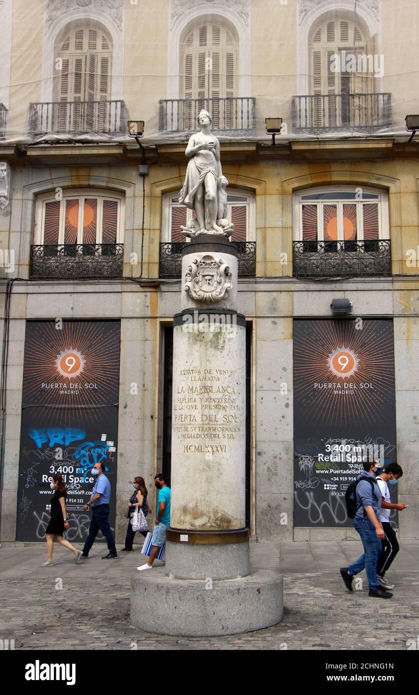 Estatua de Venus llamada la Mariblanca en una alta columna Puerta del Sol Madrid España con peatones caminando por el verano durante la pandemia Foto de stock