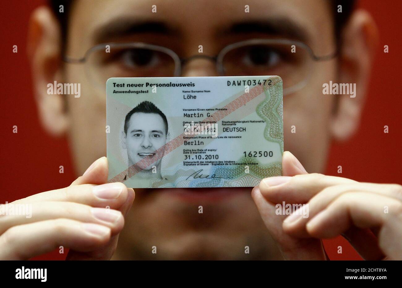 A Man Poses For The Photographer With The Front Side Of A Sample Of The New German Id Card Personalausweis In Berlin October 27 10 The Card Can Be Ordered From November