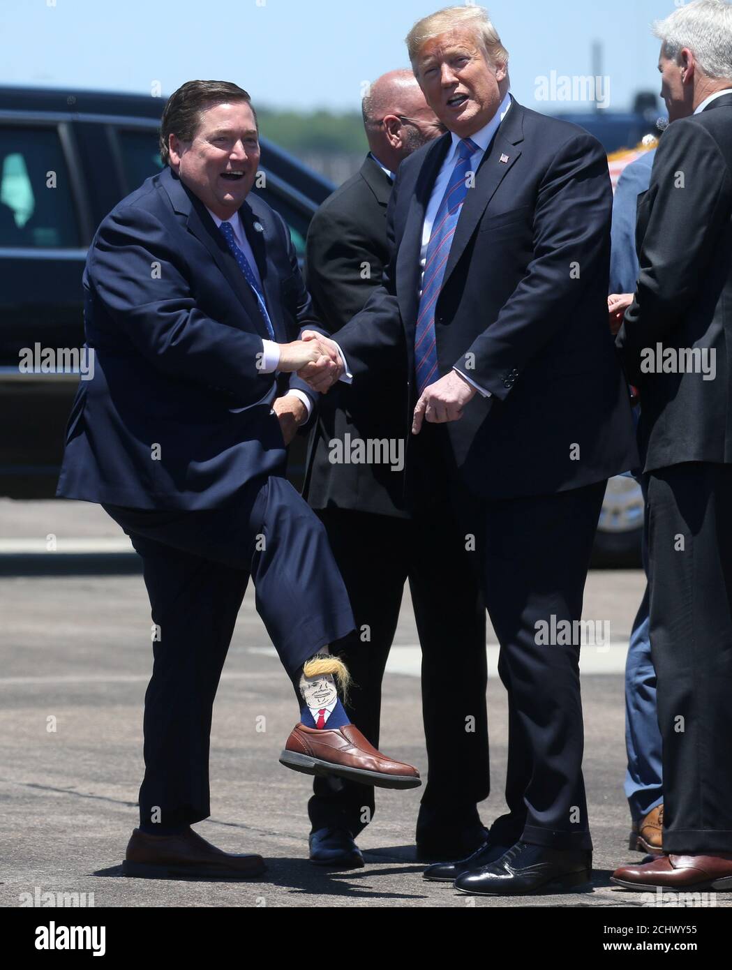 El presidente estadounidense Donald Trump es recibido por el Vicegobernador  de Luisiana Billy Nungesser mostrando sus calcetines de Trump cuando el  presidente llega a Lake Charles, Louisiana, EE.UU., el 14 de mayo