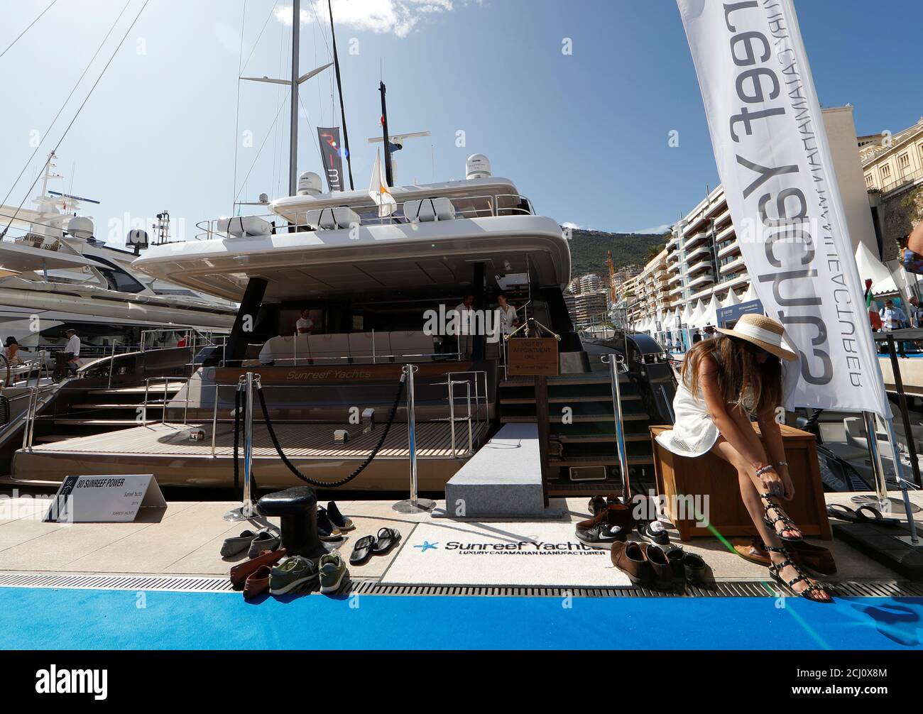 Un visitante se quita sus zapatos antes de subir a un barco durante el  Mónaco Yacht Show, uno de los más prestigiosos espectáculos de  embarcaciones de recreo en el mundo, destacando cientos