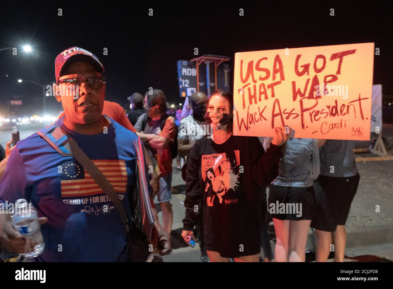 Henderson, NV, EE.UU. 13 de septiembre de 2020. Un partidario del presidente Donald Trump argumenta en contra del movimiento Black Live Matter mientras los manifestantes tienen un signo anti-Trump con una cita de Cardi B a su lado. Aproximadamente 10 manifestantes se presentaron al mitin del presidente Donald Trump en Henderson, NV cantando y sosteniendo señales fuera del edificio Xtreme Manufacturing donde Trump estaba hablando. Crédito: Young G. Kim/Alamy Live News Foto de stock