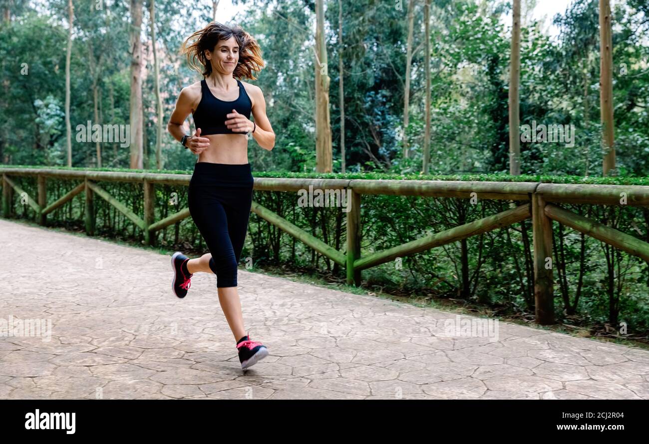Mujer corriendo a través de un parque Foto de stock