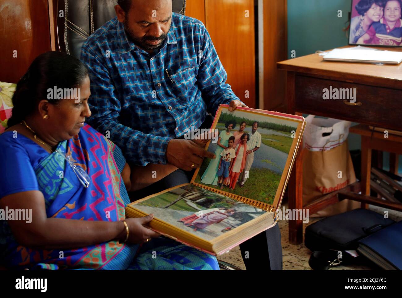 Karibeeran Paramesvaran y su esposa Choodamani, que perdió a tres niños en el tsunami de 2004, muestran su álbum familiar dentro de su casa que se han convertido en un hogar para niños huérfanos en el distrito de Nagapattinam en el estado sureño de Tamil Nadu, India, el 4 de diciembre de 2019. Foto tomada el 4 de diciembre de 2019. REUTERS/P. Ravikumar Foto de stock