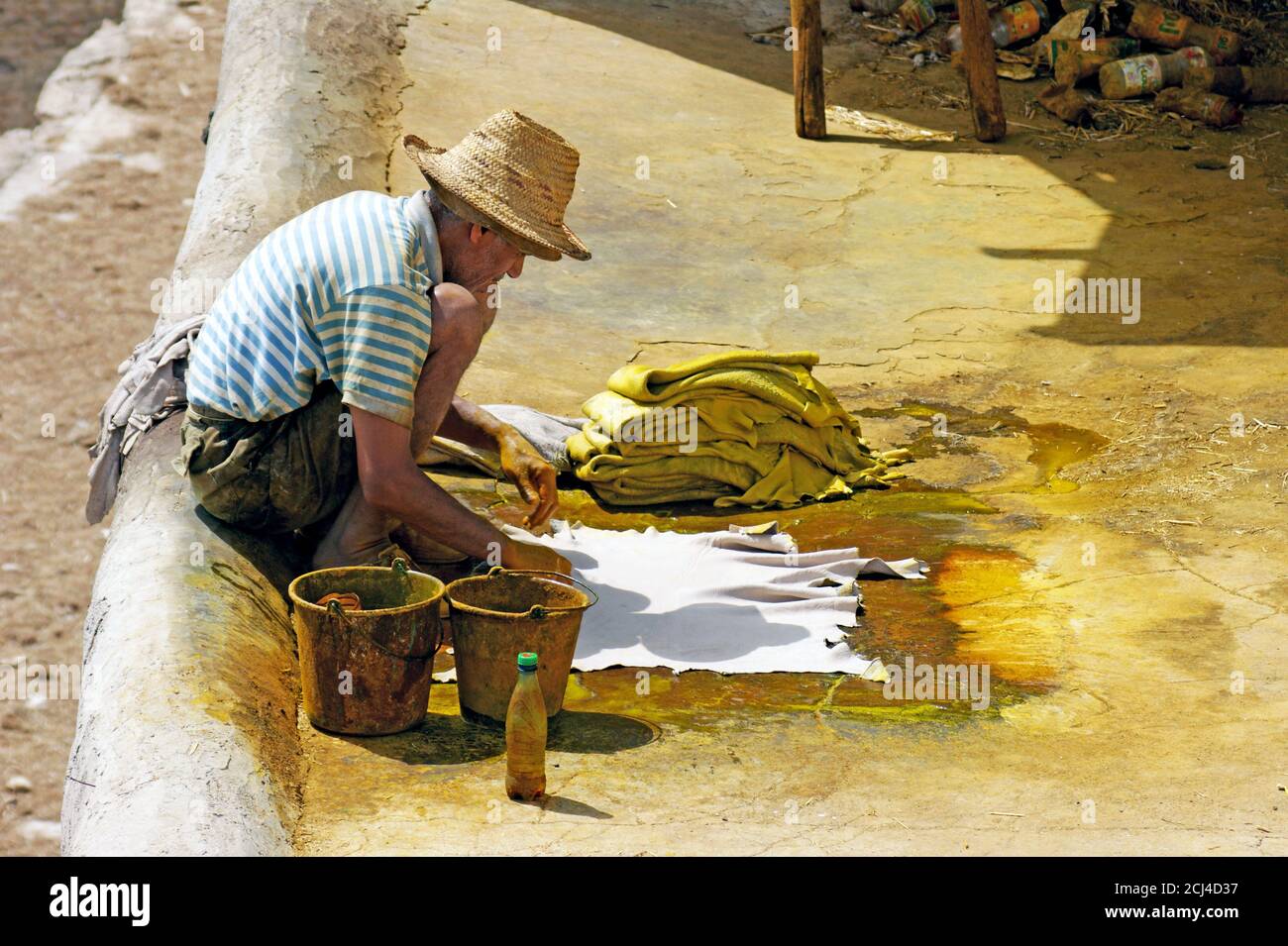 Un viejo hombre de Moroccon trabaja en el proceso de coloración del cuero en la curtiduría de Chouara en Fez, Marruecos. Foto de stock