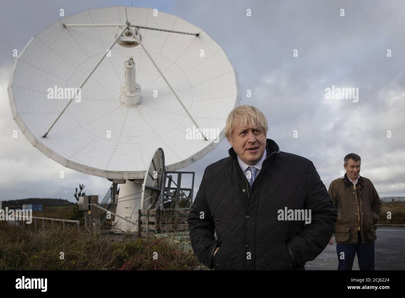 El primer ministro británico Boris Johnson se muestra alrededor de platos satelitales propiedad de la compañía de telecomunicaciones Avanti por el director de tecnología, Scott Richardson, en la estación terrestre de Goonhilly, en Helston, Gran Bretaña, el 27 de noviembre de 2019. Dan Kitwood/Pool vía REUTERS Foto de stock