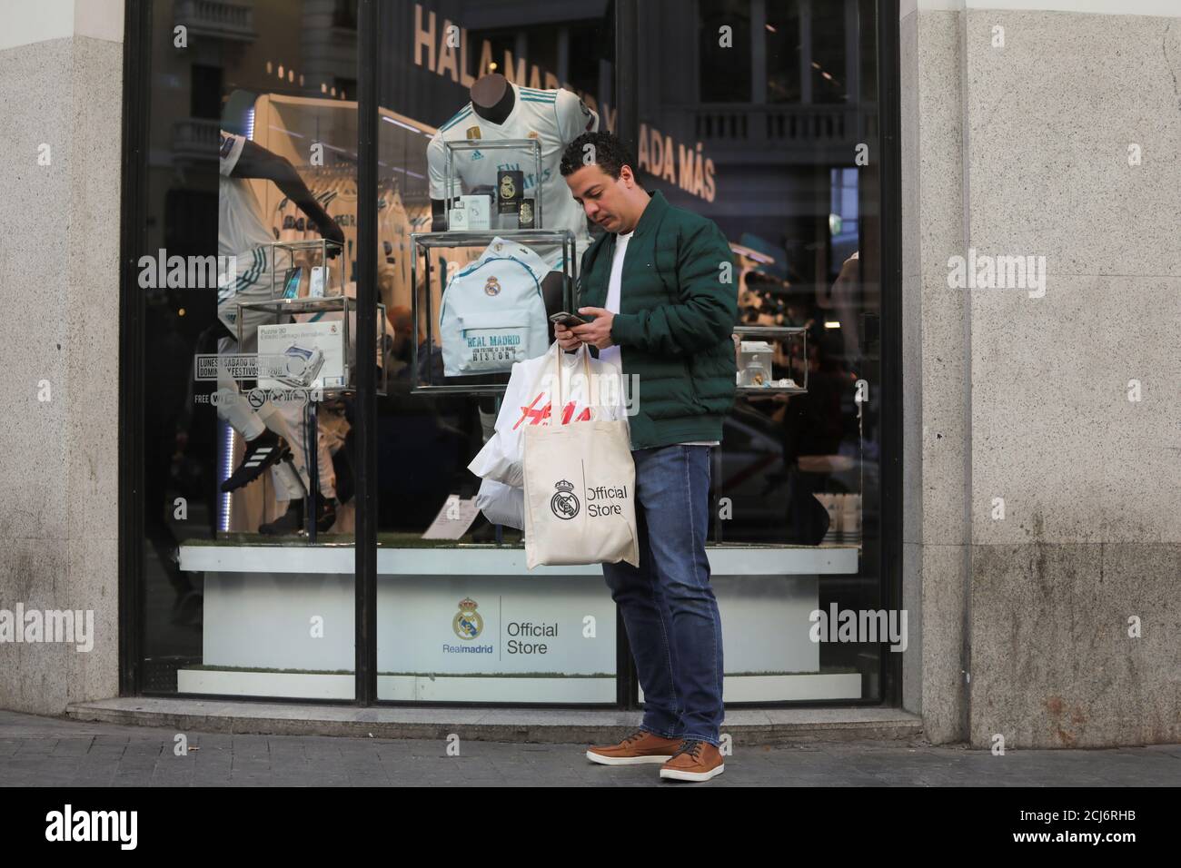 Un cliente sale con sus compras en la tienda del Real Madrid en el centro  de Madrid, España, el 20 de diciembre de 2017. REUTERS/Sergio Pérez  Fotografía de stock - Alamy