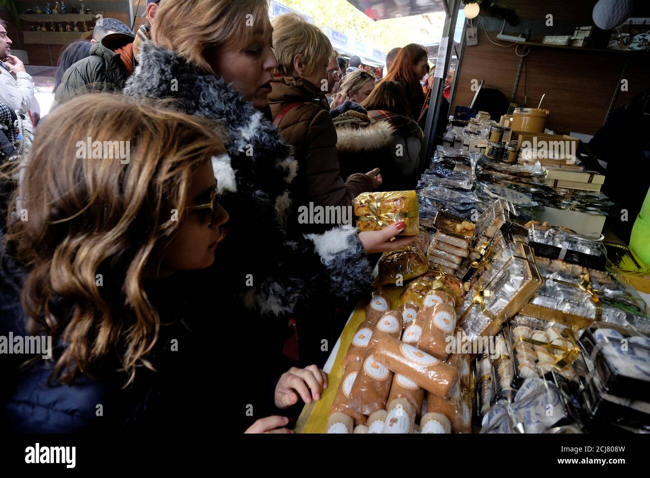 La gente hace cola en un puesto durante una feria de Navidad con dulces tradicionales en Jijona, cerca de Alicante, España, 8 de diciembre de 2017. REUTERS/Heino Kalis Foto de stock